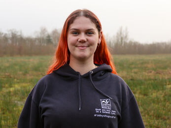 Marianne stood in a field with a WTSWW hoody on. 
