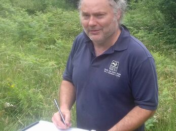 Doug with a clipboard outside. 