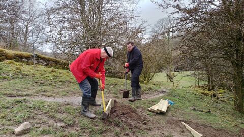 Two volunteers working to repair steps at a nature reserve