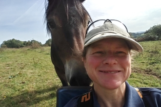 A woman talking a selfie with horse.