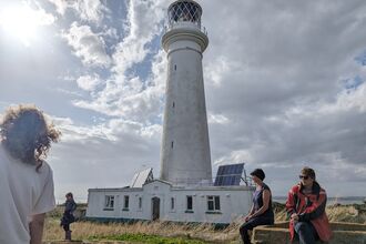 Visitors to Flat Holm Island in front of the lighthouse