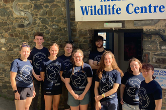 A group of people stood in front of a sign saying Cardigan Bay Marine Wildlife Centre