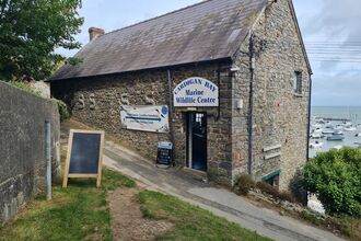 A stone building with a sign saying Cardigan Bay Marine Wildlife Centre. 