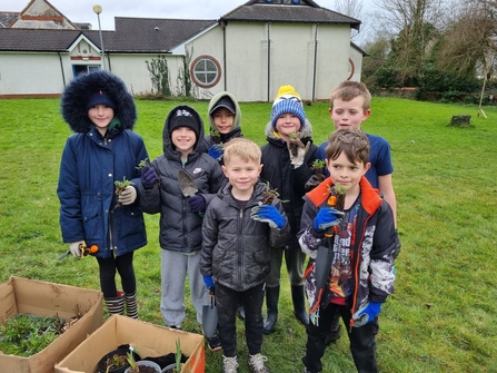 Group of children holding plant plugs. 