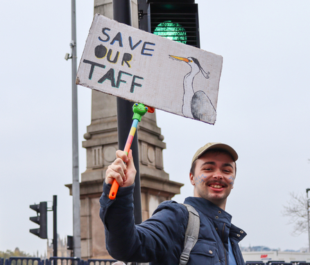 A young man holding a sign which reads 'Save Our Taff'.