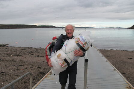Steve carrying equipment on a pier 