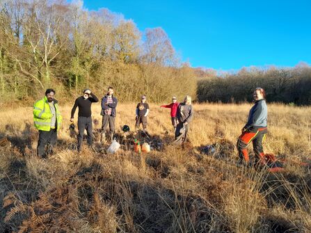 Volunteers in a field smiling at the camera