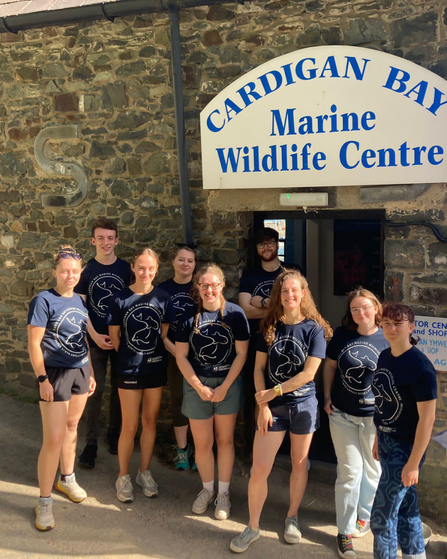 A group of people stood in front of a sign saying Cardigan Bay Marine Wildlife Centre