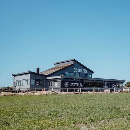 In the Welsh Wind Distillery - a grey building which has the words distillery on it. 